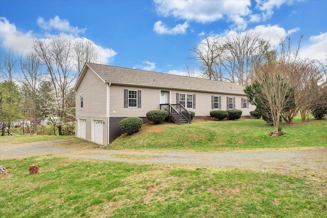 ranch-style home featuring dirt driveway, a front lawn, and a garage