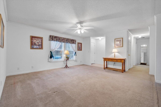 unfurnished room with baseboards, ornamental molding, a ceiling fan, a textured ceiling, and carpet flooring
