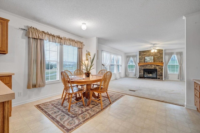 dining area with a fireplace, light floors, a textured ceiling, a ceiling fan, and visible vents