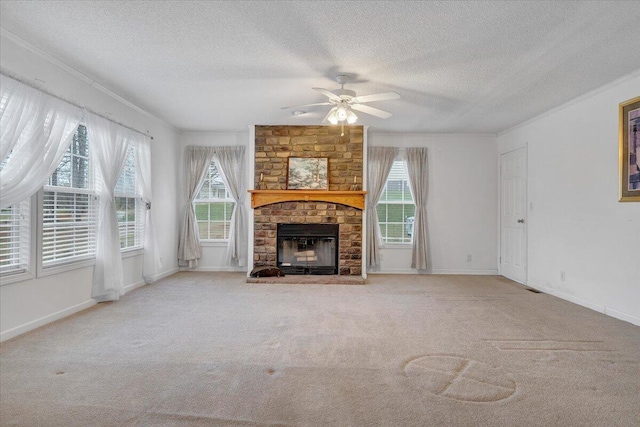 unfurnished living room featuring baseboards, ornamental molding, ceiling fan, a fireplace, and carpet flooring