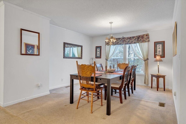 dining room with a chandelier, light carpet, crown molding, and a textured ceiling