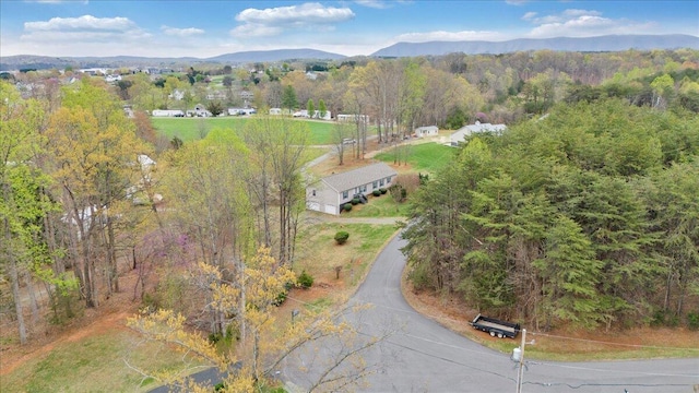 birds eye view of property with a forest view and a mountain view