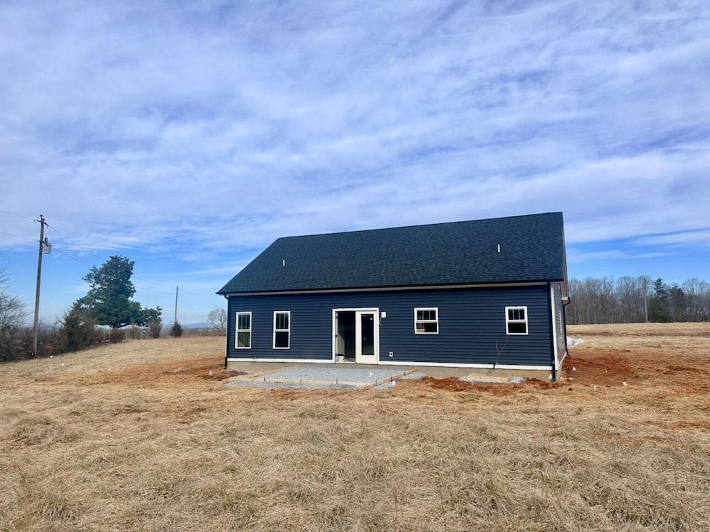 back of property featuring a patio area and a shingled roof