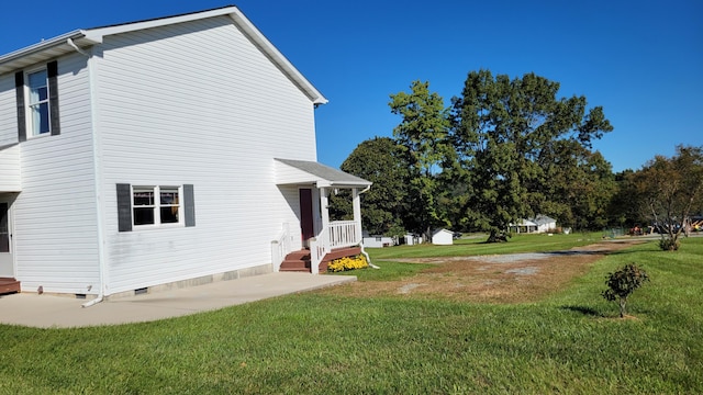 view of side of home with crawl space and a lawn