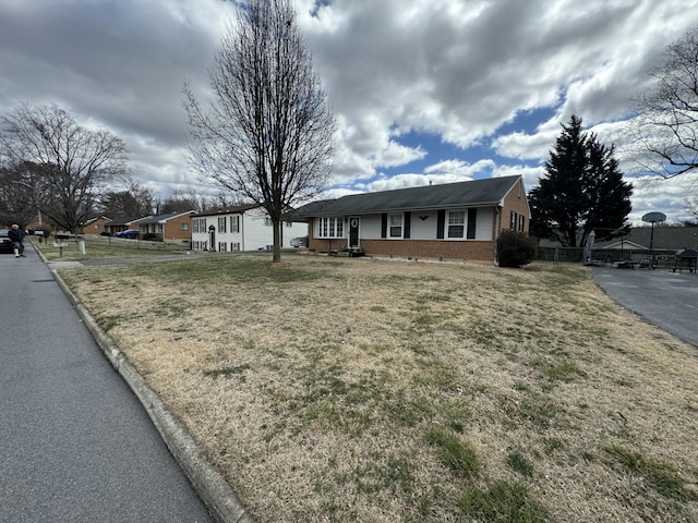 single story home with brick siding, a front yard, and fence