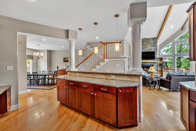 kitchen featuring a healthy amount of sunlight, light wood-style flooring, decorative columns, and open floor plan