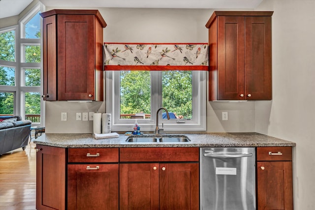 kitchen featuring stone countertops, wood finished floors, a sink, dark brown cabinets, and stainless steel dishwasher