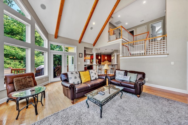 living area with plenty of natural light, high vaulted ceiling, wood-type flooring, and beam ceiling