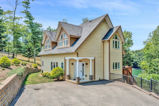 view of front of house with a shingled roof and aphalt driveway