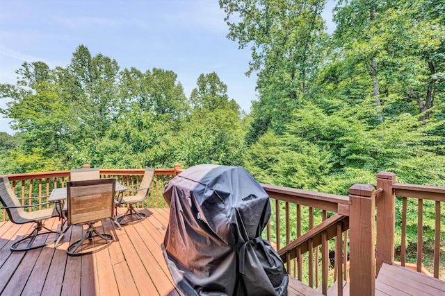 wooden deck with outdoor dining space and area for grilling