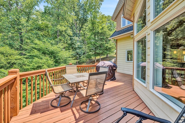 wooden deck with grilling area and outdoor dining area