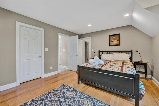 bedroom with vaulted ceiling, recessed lighting, wood finished floors, and baseboards