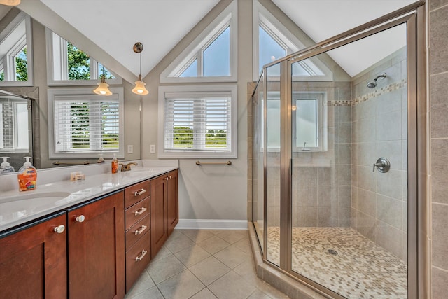 bathroom with double vanity, a stall shower, tile patterned floors, vaulted ceiling, and a sink