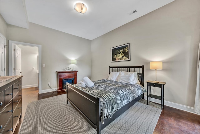 bedroom with baseboards, a fireplace, and visible vents