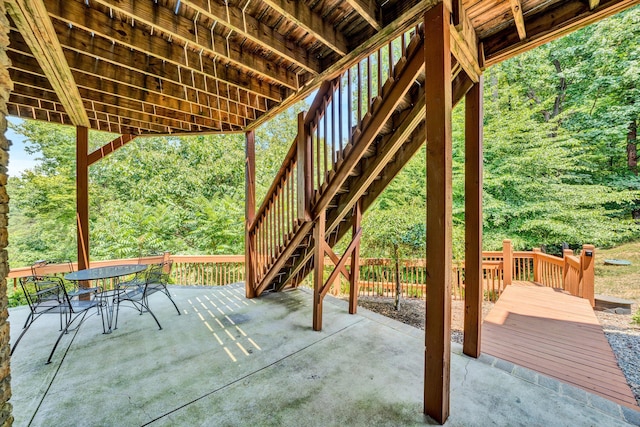 view of patio with outdoor dining area and stairs