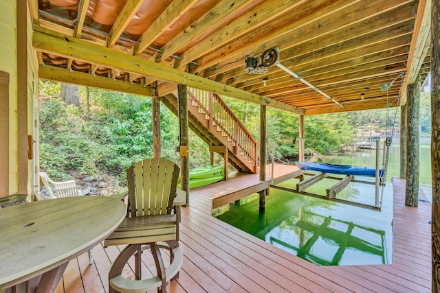 wooden terrace with stairs, a boat dock, and boat lift