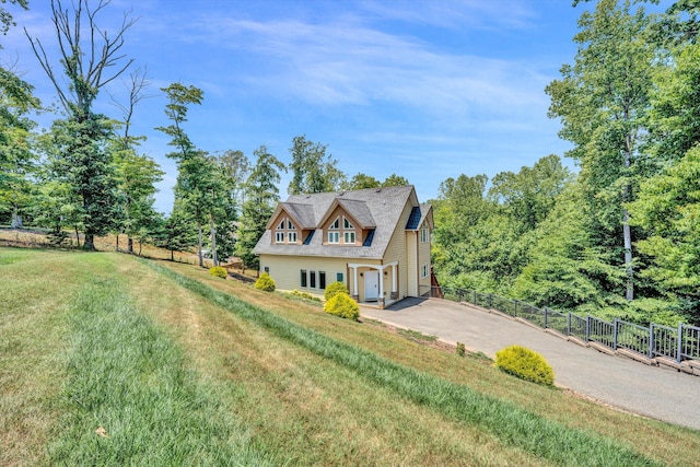 view of side of property with a yard, fence, and driveway