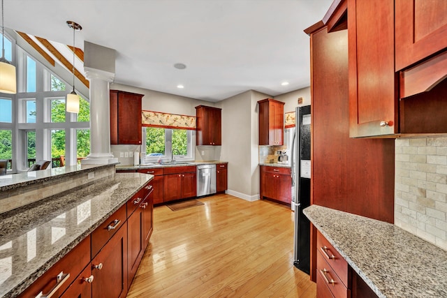 kitchen with decorative backsplash, light wood-style flooring, appliances with stainless steel finishes, decorative light fixtures, and ornate columns