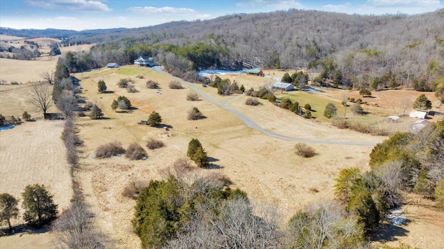 drone / aerial view featuring a wooded view and a rural view