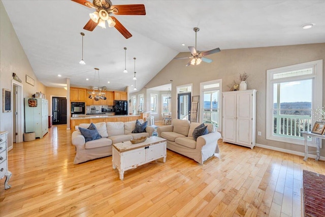 living area featuring light wood-style floors, high vaulted ceiling, baseboards, and a ceiling fan