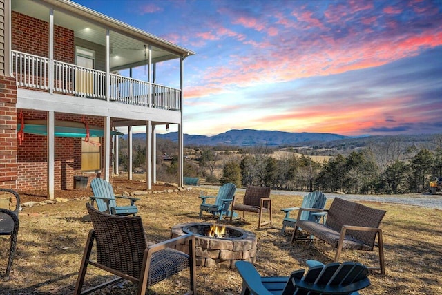 view of patio with an outdoor fire pit and a mountain view