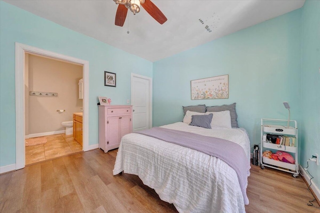 bedroom with a ceiling fan, light wood-style flooring, baseboards, and connected bathroom