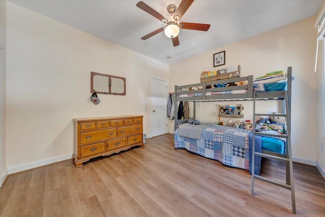 bedroom featuring ceiling fan, baseboards, and wood finished floors