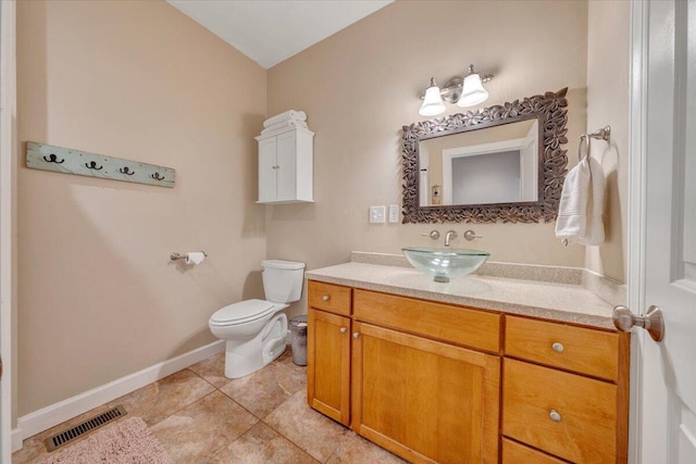 bathroom featuring tile patterned flooring, toilet, vanity, visible vents, and baseboards