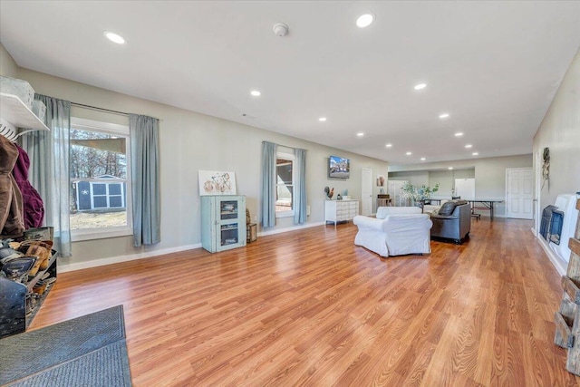 unfurnished living room featuring recessed lighting, light wood-style flooring, and baseboards