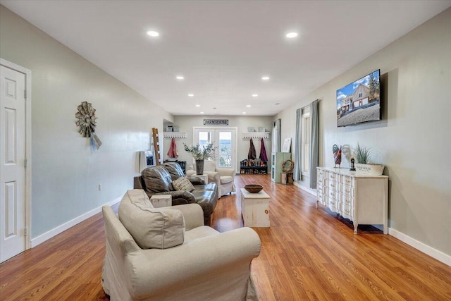 living room with light wood-type flooring, baseboards, and recessed lighting