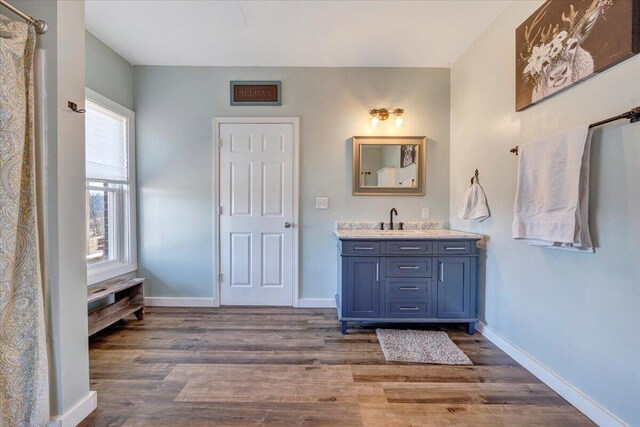 full bathroom with wood finished floors and baseboards