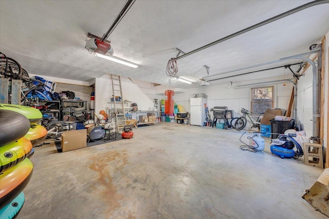 garage with freestanding refrigerator and a garage door opener