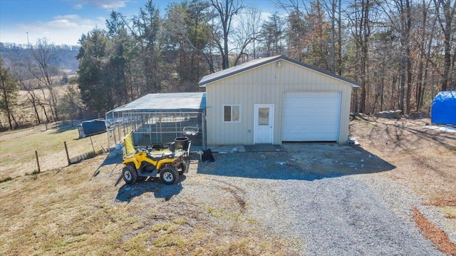 detached garage with gravel driveway and fence