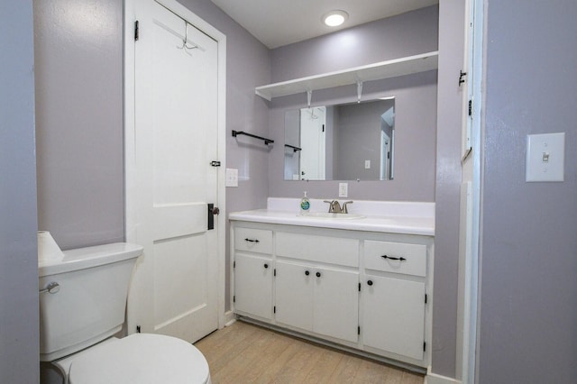 bathroom with vanity, wood finished floors, and toilet