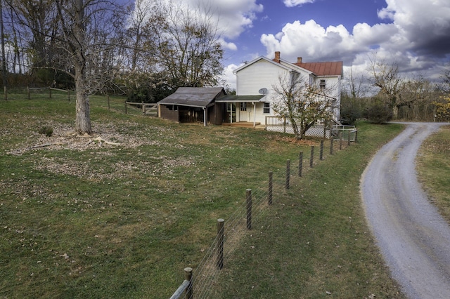 view of yard featuring driveway and fence