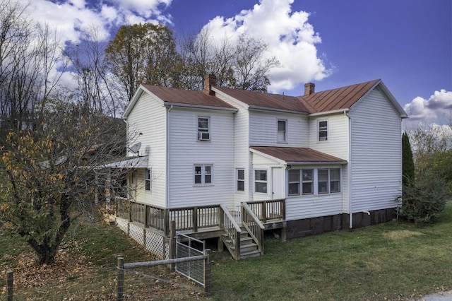 rear view of house featuring a yard, a chimney, and a wooden deck