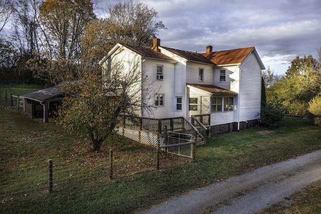 exterior space featuring a front yard, a chimney, and a wooden deck