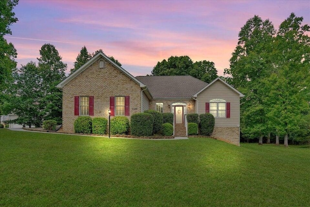 ranch-style home featuring brick siding and a front yard