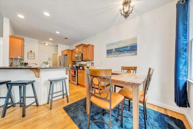 dining area featuring light wood-style floors, baseboards, and recessed lighting