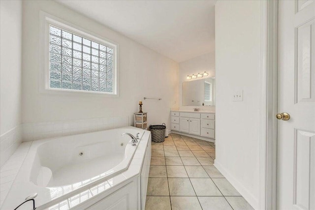 bathroom featuring a jetted tub, vanity, and tile patterned floors