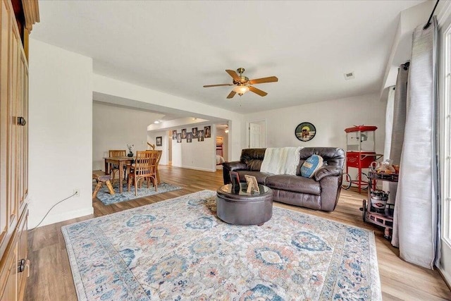 living room with visible vents, ceiling fan, and light wood-style flooring