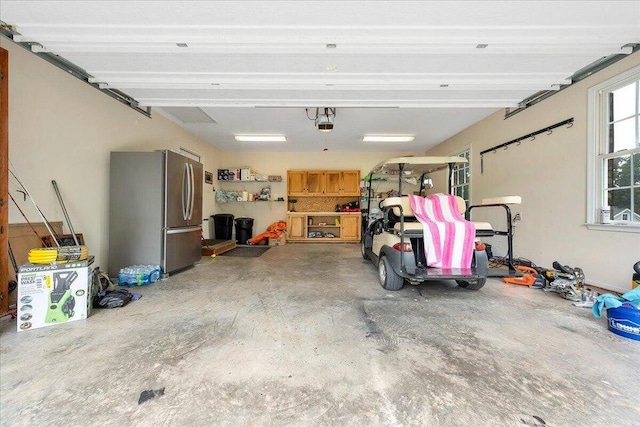 garage featuring a garage door opener and freestanding refrigerator