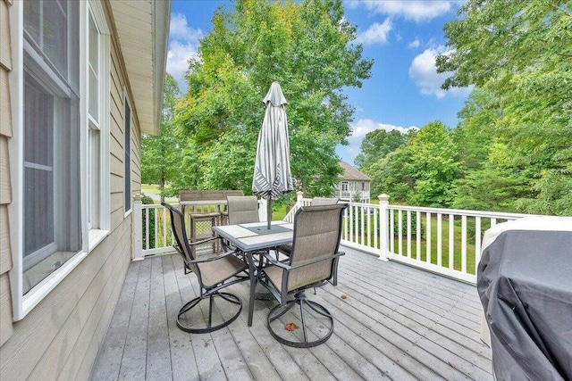 wooden terrace with grilling area and outdoor dining area