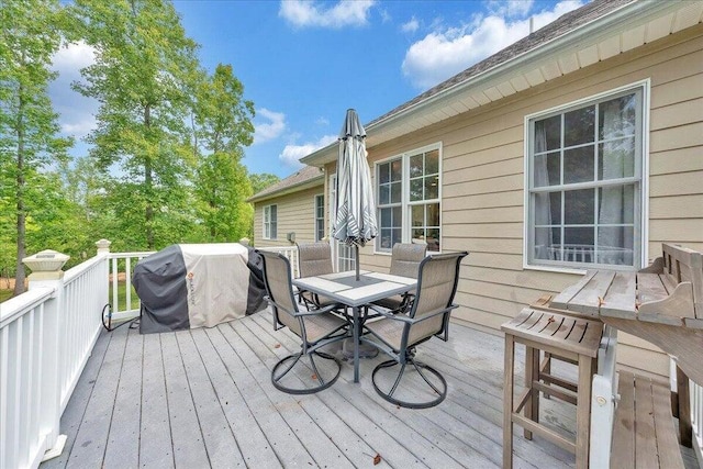 deck with outdoor dining space and area for grilling