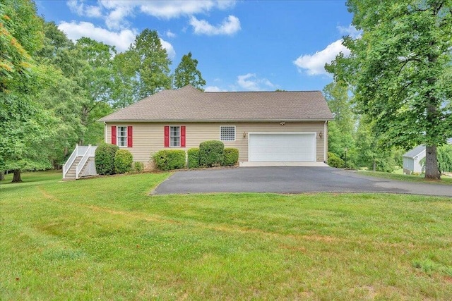 view of side of property with a garage, aphalt driveway, and a lawn