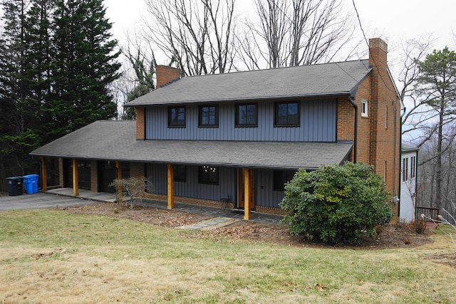 view of front of house featuring a garage, driveway, a chimney, and a front lawn