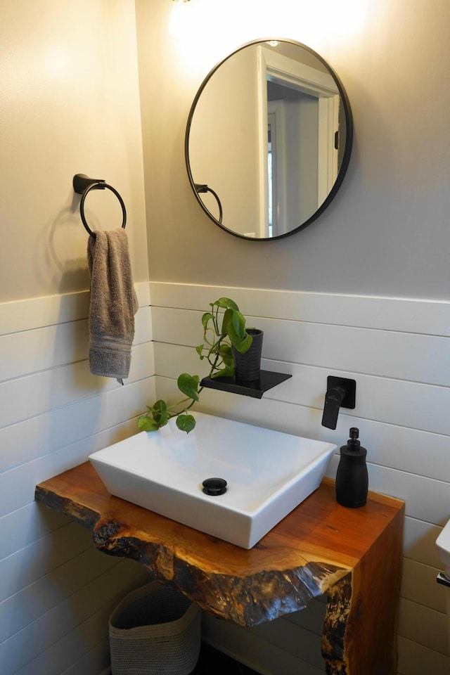 bathroom with a wainscoted wall and a sink