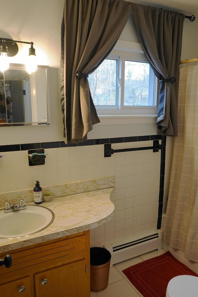 bathroom with toilet, baseboard heating, vanity, and tile walls