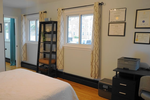 bedroom featuring light wood finished floors and multiple windows