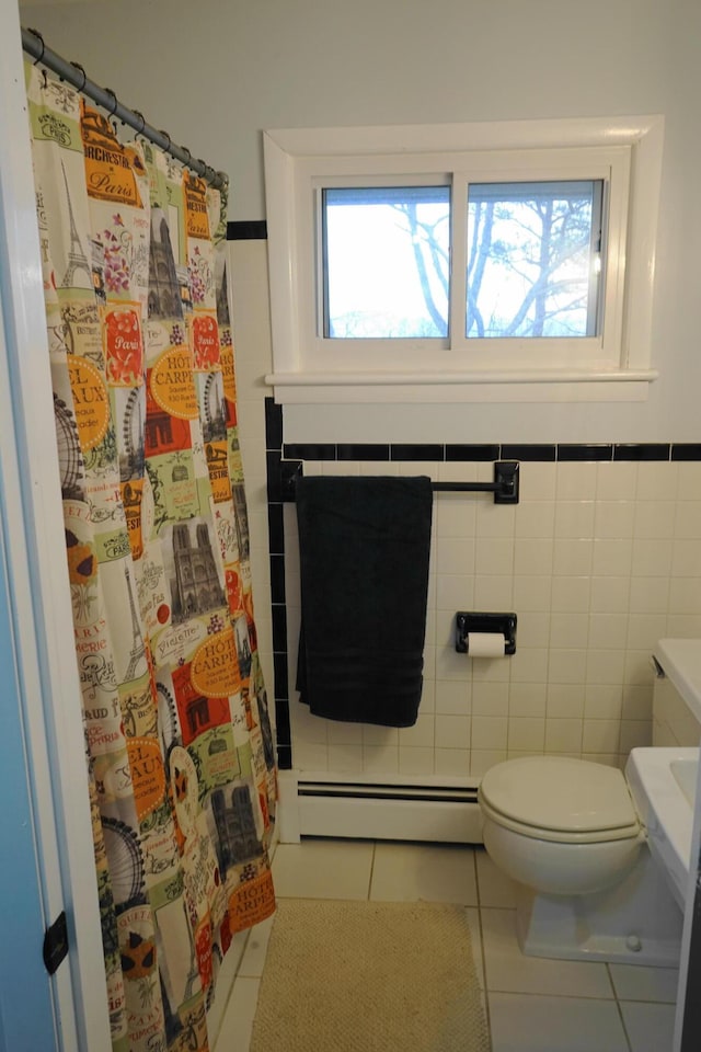 bathroom with toilet, a wainscoted wall, a baseboard radiator, tile patterned flooring, and tile walls